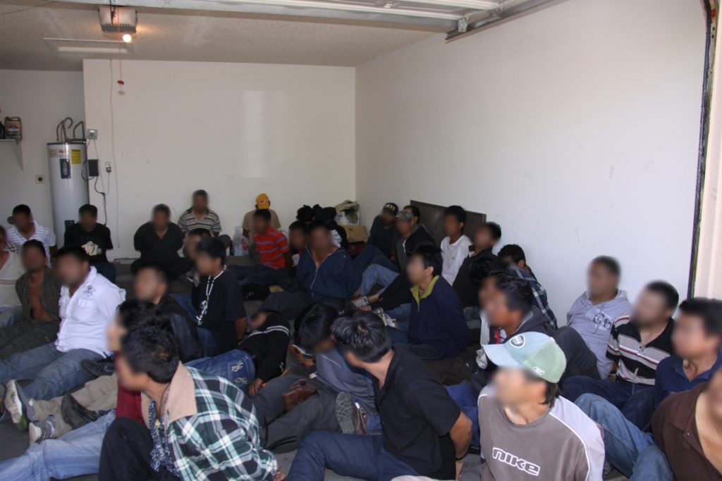 Este grupo numeroso de migrantes fue reunido en la cochera de una casa después de haber sido encontrados por las autoridades. Foto: Cortesía CBP