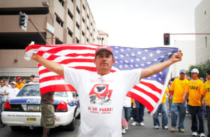 Un hombre levanta la bandera de Estados Unidos sobre su espalda durante una marcha en Phoenix, Arizona a favor una reforma migratoria. Los inmigrantes mexicanos constituyen el mayor grupo en comparación con otros grupos étnicos en el país. Foto: Eduardo Barraza © 2020
