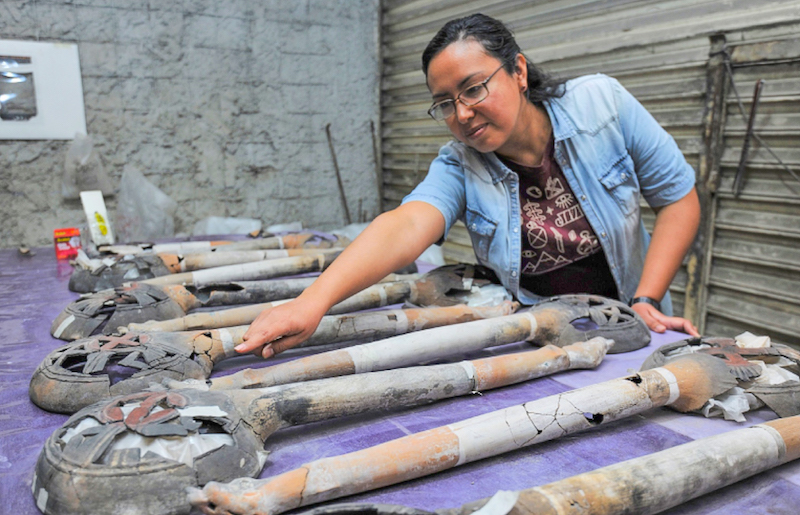 La arqueóloga del INAH Mara Abigaíl Becerra examina los 13 sahumadores encontrados durante la excavación del sitio donde se descubrió la ofrenda mexica. Foto Mauricio Marat | INAH