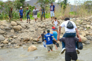 Un grupo de personas atraviesa el Río Táchira en el sector conocido como "La Playita", en la frontera entre Colombia y Venezuela. Uno de los mayores movimientos migratorios en el hemisferio occidental es el éxodo de millones venezolanos a Colombia. Foto: Daniel Cima | Comisión Interamericana de Derechos Humanos