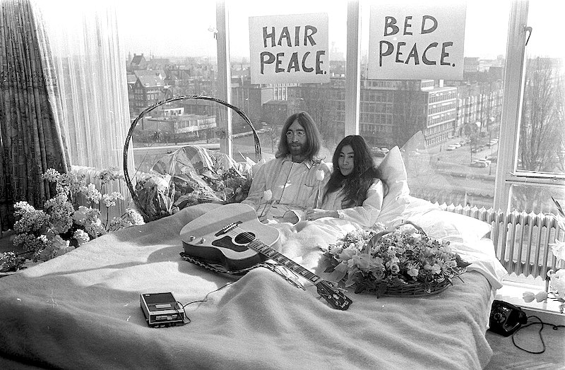 El 25 de marzo de 1969, John Lennon y Yoko Ono fueron fotografiados en la cama de una habitación en un hotel en Ámsterdam, Holanda, durante una de sus dos 'encamadas por la paz'. Estas acciones se llevaron a cabo como una forma de protesta no violenta contra la guerra. Foto: Eric Koch | Anefo | Creative Commons."