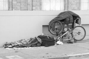 Una persona acostada sobre una banqueta en San Francisco, California, ilustra la situación en la que miles de personas sin hogar se ven obligadas a dormir en la calle debido a situaciones crónicas, la falta de vivienda y espacio en los refugios. Foto: Franco Folini | Flickr | Creative Commons