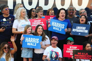 A group of women supporting abortion rights hold signs in favor of the cause next to the blue campaign bus of Kamala Harris and Tim Walz, "Fighting for Reproductive Freedom," in Phoenix, Arizona, on October 12, 2024. The campaign event featured U.S. First Lady Jill Biden, who delivered a speech in defense of reproductive rights. Photo: Eduardo Barraza | Barriozona Magazine © 2024