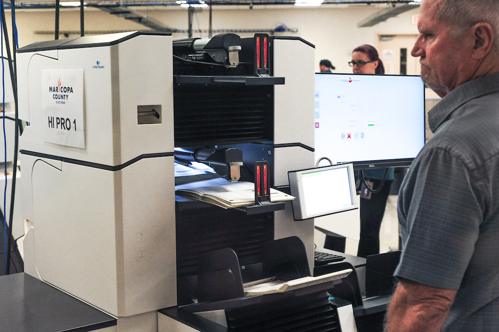 A Maricopa County election worker supervises the test count of a ballot tabulation machine in preparation for the November 5, 2024, general election. This test was conducted at the Maricopa County Tabulation and Election Center (MCTEC) in Phoenix, Arizona. Photo: Eduardo Barraza | Barriozona Magazine © 2024