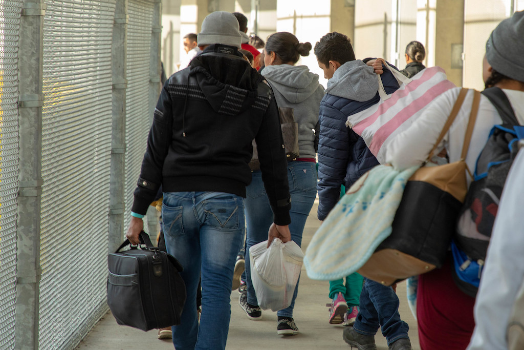 Una imagen de archivo muestra a un grupo de migrantes, entre ellos algunos que buscan asilo, en el puerto de entrada de San Ysidro, California. La orden ejecutiva firmada por Donald Trump, que intensifica las políticas migratorias a partir de enero de 2025, sostiene que, en los últimos cuatro años, un "flujo sin precedentes" de inmigración ilegal ha representado una grave amenaza para la seguridad nacional y pública.